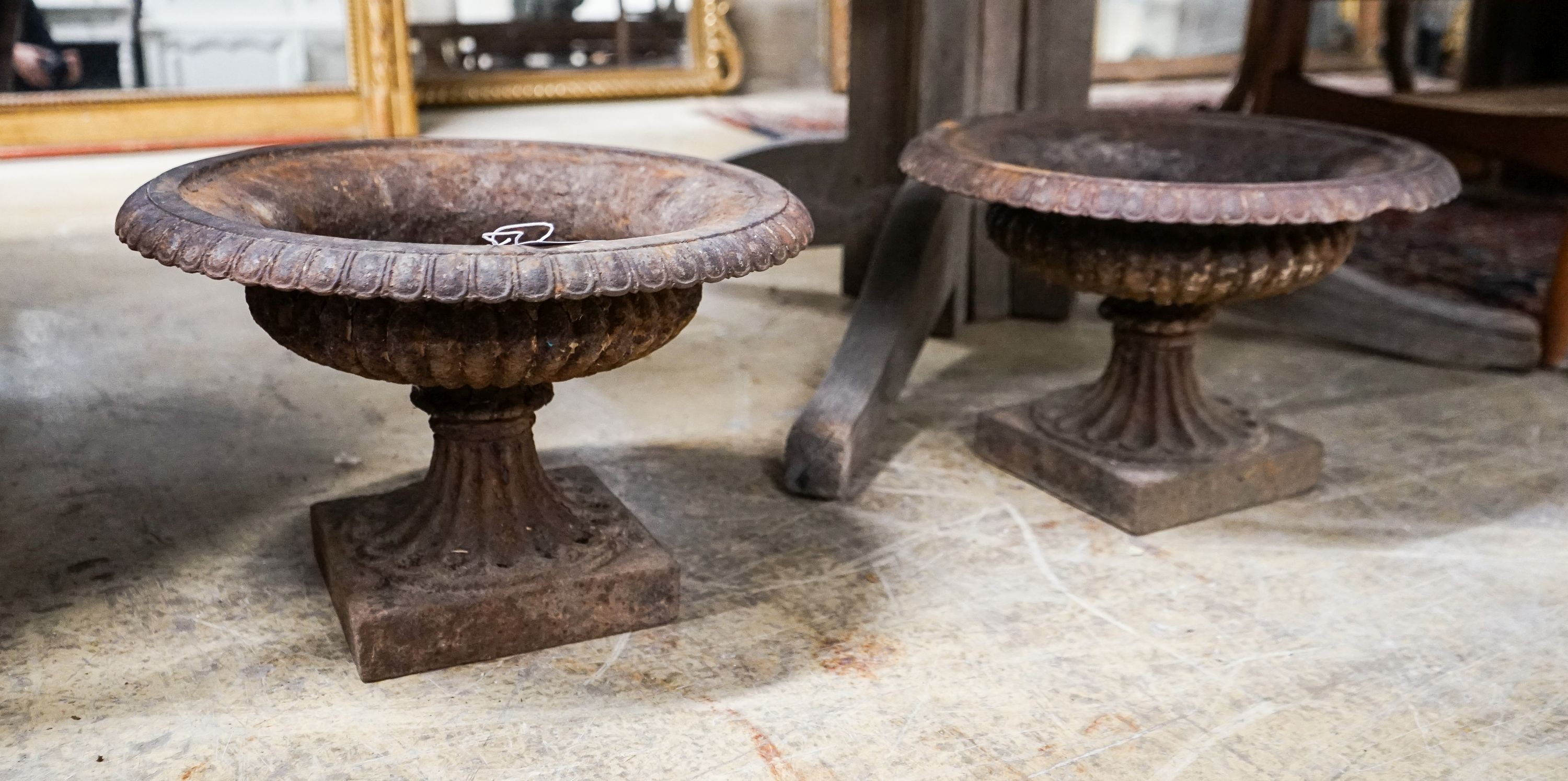 A pair of Victorian cast iron campana garden urns, diameter 38cm, height 25cm